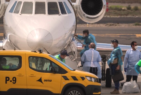 A passenger boards a French government plane after disembarking from the hantavirus-stricken cruise ship MV Hondius at the airport in Tenerife, Canary Islands, Spain, Sunday, May 10, 2026. (AP Photo/Arturo Rodriguez)