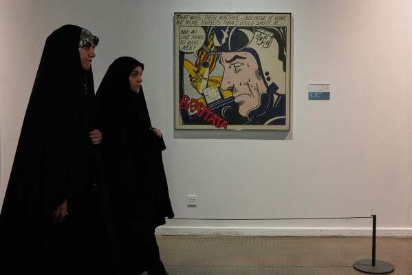 Iranian women walk past American artist Roy Lichtenstein's "Brattata" as they visit an exhibition called: "Art & war" displaying some artworks of American pop artists at the Tehran Museum of Contemporary Art in Iran, Thursday, May 7, 2026. (AP Photo/Vahid Salemi)