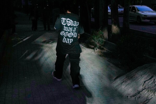 A man wears a T-shirt with a part of "It was a good day" song lyrics by the American rapper Ice Cube on its back as he walks on a sidewalk in northern Tehran, Iran, Sunday, May 10, 2026. (AP Photo/Vahid Salemi)