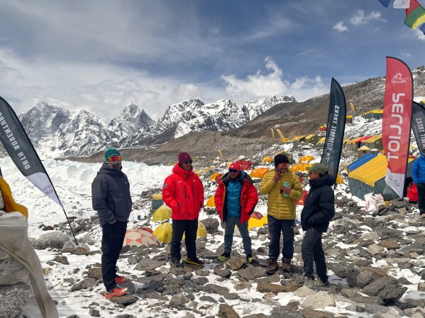 Guides and mountaineers stand outside their tents during acclimatization period before attempting the Mount Everest ascent at the base camp, Nepal, Sunday, May 10, 2026. (AP Photo/Pasang Rinzee Sherpa)