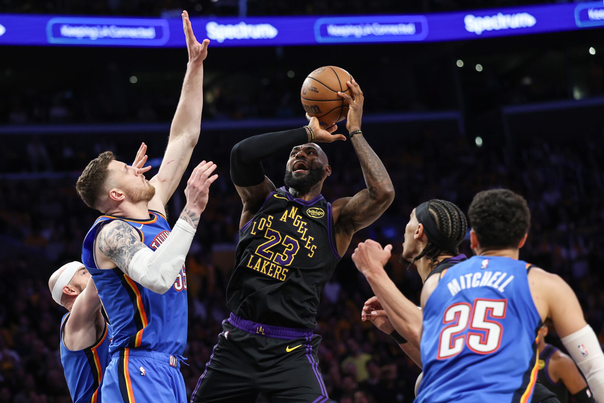 Lakers star LeBron James tries to shoot over Oklahoma City Thunder center Isaiah Hartenstein.