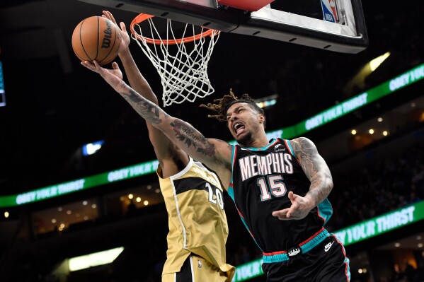 Memphis Grizzlies forward Brandon Clarke (15) shoots against Washington Wizards center Alex Sarr (20) in the first half of an NBA basketball game, Dec. 20, 2025, in Memphis, Tenn. (AP Photo/Brandon Dill)