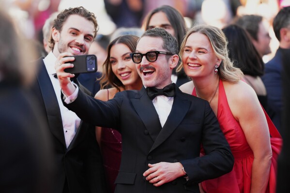 Elijah Wood, centre, takes a selfie photogragh with William Jackson, from left, Katie Jackson and Mette-Marie Kongsved at the opening ceremony and premiere of the film 'The Electric Kiss' during 79th international film festival, Cannes, southern France, Tuesday, May 12, 2026. (Photo by Scott A Garfitt/Invision/AP)