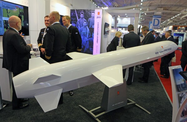 Visitors are gathered next to a display of an NSM Naval Strike Missile made by Norwegian company Kongsberg, presented at the Euronaval show, in Le Bourget, North of Paris, France, Wednesday Oct. 29, 2014. (AP Photo/Remy de la Mauviniere)