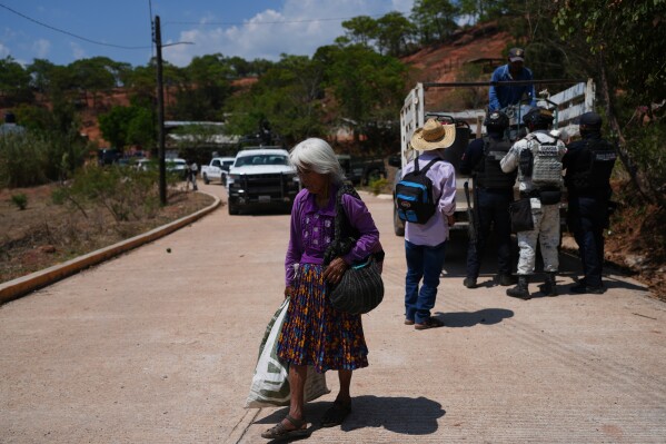 A resident walks along a street after armed attacks by local criminal groups forced more than dozens of residents to flee, in Tula, Mexico, Friday, May 15, 2026. (AP Photo/Marco Ugarte)