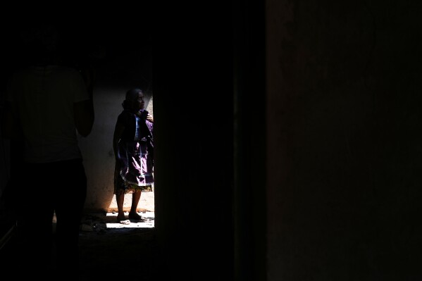 Maria Anastasia Cabrera walks through the ruins of her home after armed attacks by local criminal groups forced dozens of residents to flee, in Tula, Mexico, Friday, May 15, 2026. (AP Photo/Marco Ugarte)