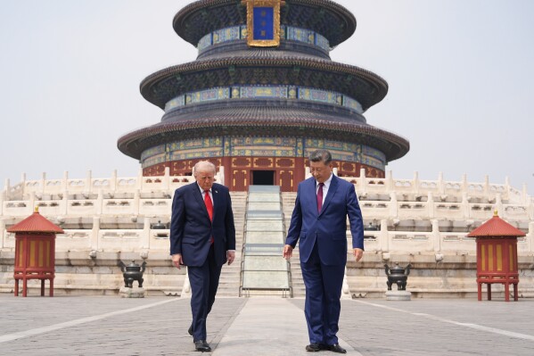 President Donald Trump, left, walks with Chinese President Xi Jinping at the Temple of Heaven on Thursday, May 14, 2026, in Beijing. (AP Photo/Mark Schiefelbein)