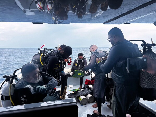 This image released by the Maldives President's Media Division, shows divers preparing to search for the four missing Italian divers near Alimathaa Island, Vaavu Atoll, Maldives, Saturday, May 15, 2026. (Maldives President's Media Division via AP)