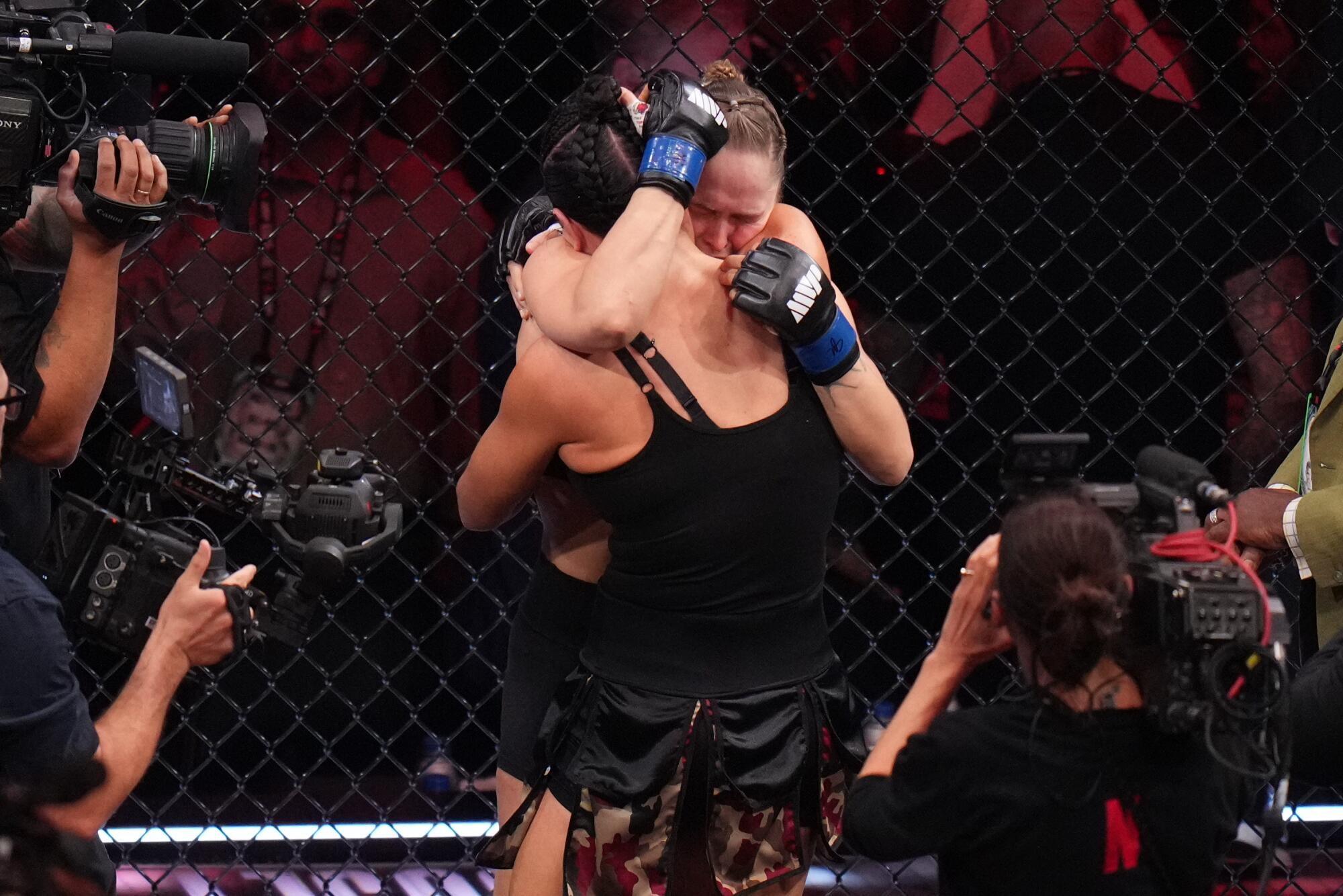Ronda Rousey, of the United States, behind, hugs Gina Car 
