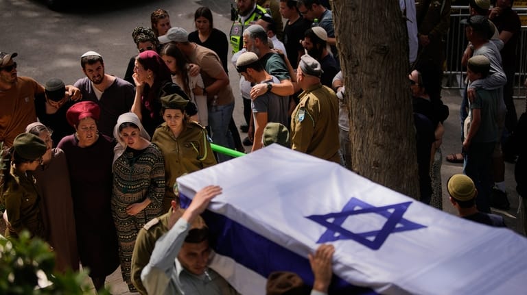 Israeli soldiers carry the flag-draped casket of Capt. Maoz Israel...
