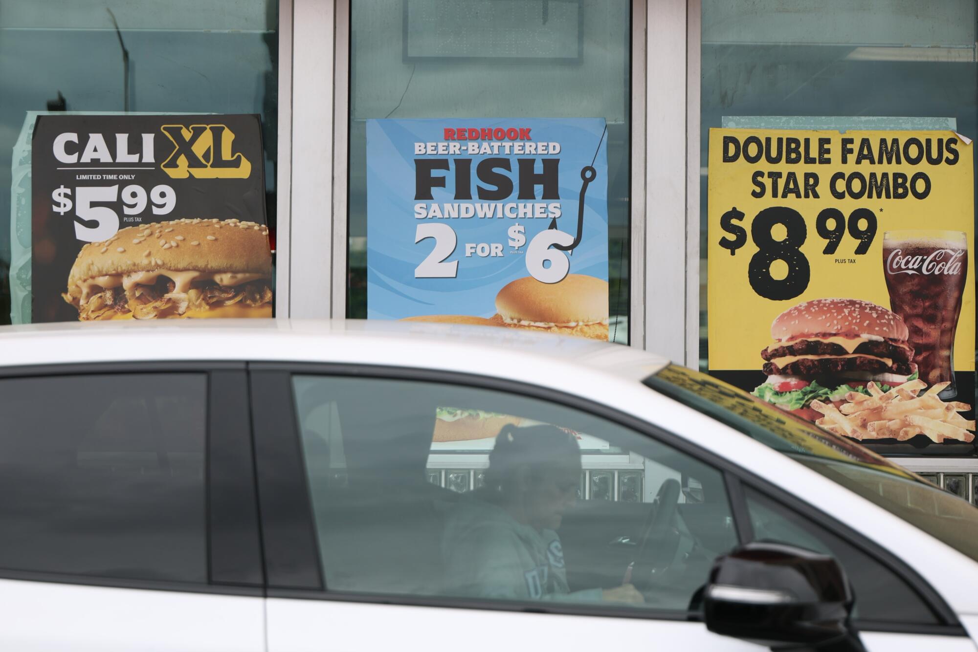 A customer sits in their car in the drive-through of a Carl's Jr. in North Hollywood.