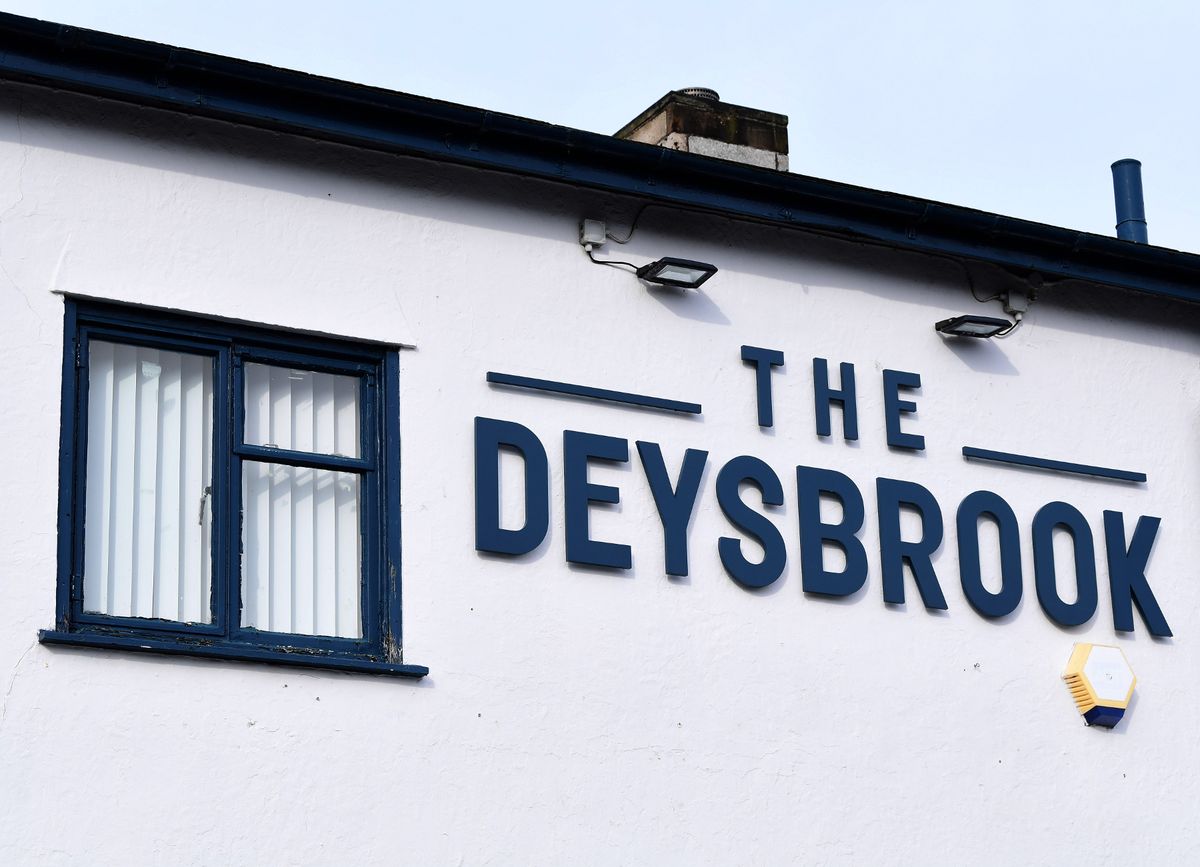 The Deysbrook sign on side of white painted building 