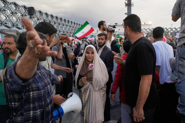 A bride holds a rose as couples are greeted by attendants during a mass wedding ceremony for participants in the "Janfada" ("Sacrifice for Iran") pro-government campaign in Tehran, Iran, Monday, May 18, 2026. (AP Photo/Vahid Salemi)