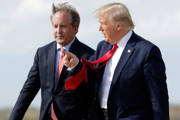 President Donald Trump walks with Texas Attorney General Ken Paxton, left, at Austin-Bergstrom International Airport in Austin, Nov. 20, 2019. (AP Photo/Evan Vucci, File)