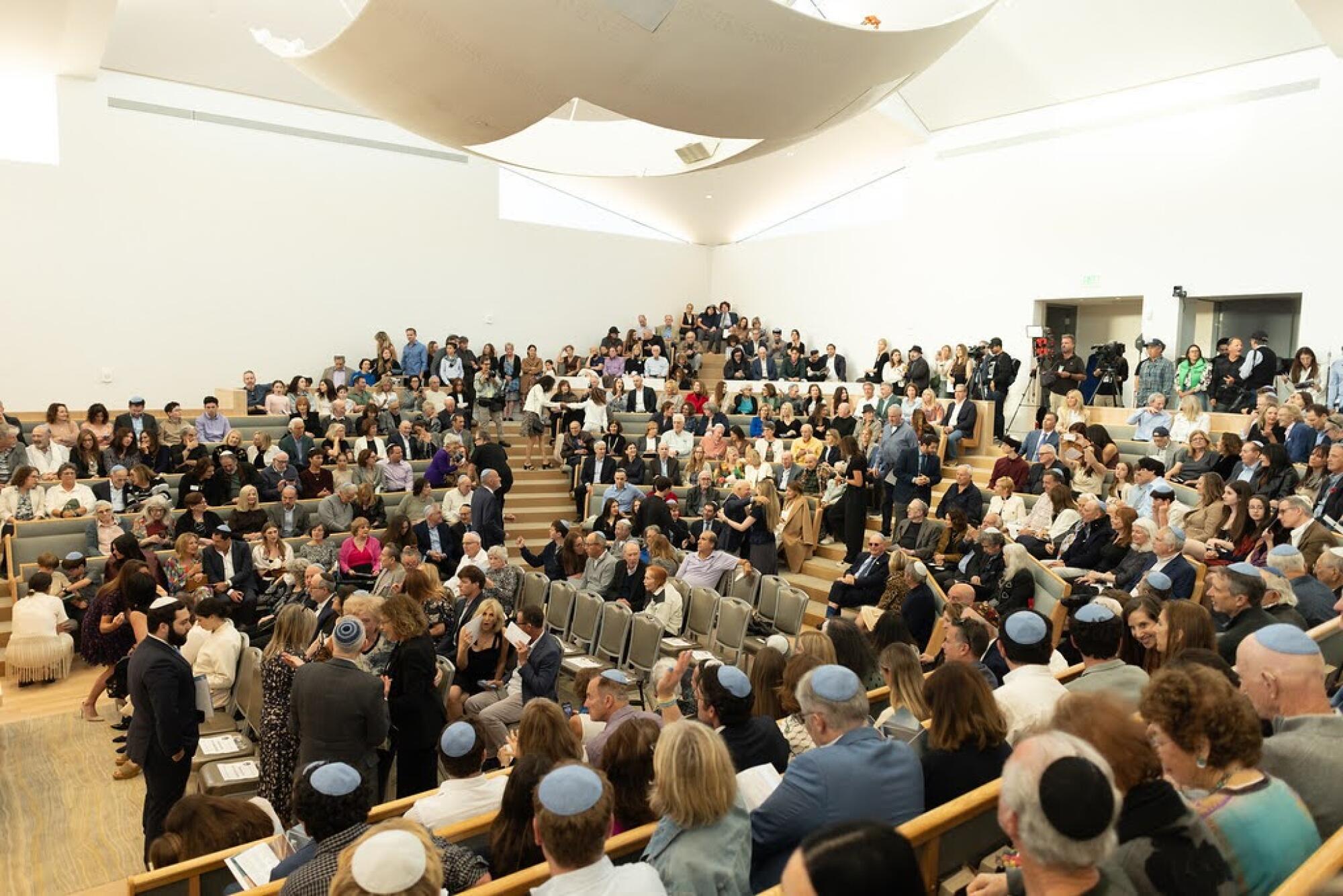 A group of people pack a temple hall.