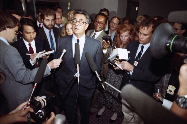 FILE - Rep. Barney Frank, D-Mass., center, speaks to reporters at a Washington hotel, Sept. 13, 1989. (AP Photo/Charles Tasnadi, File)