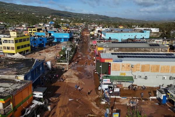 Residents walk through Santa Cruz, Jamaica, Oct. 29, 2025, after Hurricane Melissa passed. (AP Photo/Matias Delacroix, File)