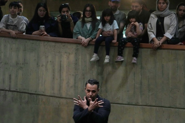 Ali Barati dances during a music performance dubbed "Sounds of the South," featuring music from southern Iran, as people watch at the Tehran Museum of Contemporary Art in Tehran, Iran, Thursday, May 21, 2026. (AP Photo/Vahid Salemi)