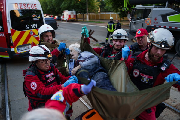 Red Cross volunteers carry an injured woman into an ambulance after a Russian strike on a residential neighborhood on Kyiv, Ukraine, on Sunday, May 24, 2026. (AP Photo/Evgeniy Maloletka)