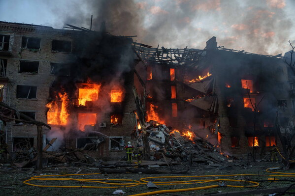 Rescue workers try to put out a fire at a residential building after a Russian strike on Kyiv, Ukraine, Sunday, May 24, 2026. (AP Photo/Evgeniy Maloletka)