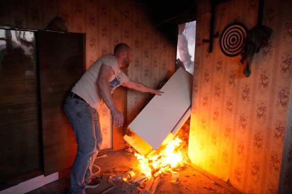 A local resident saves a refrigerator from a fire after a Russian missile attack in Kyiv, Ukraine, Sunday, May 24, 2026. (AP Photo/Efrem Lukatsky)