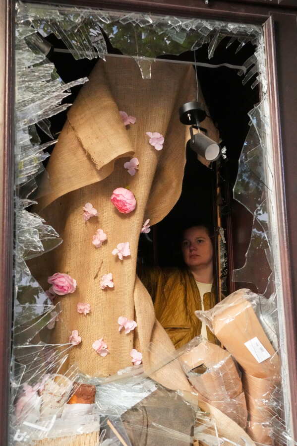 A woman is seen through the broken window after a Russian missile attack in Kyiv, Ukraine, Sunday, May 24, 2026. (AP Photo/Efrem Lukatsky)