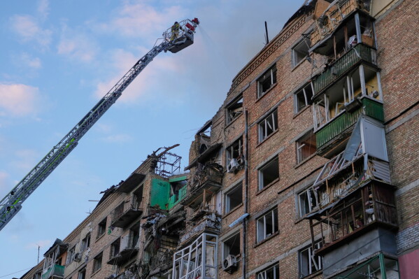 Firefighters work on the site of a burning building after a Russian missile attack in Kyiv, Ukraine, Sunday, May 24, 2026. (AP Photo/Efrem Lukatsky)