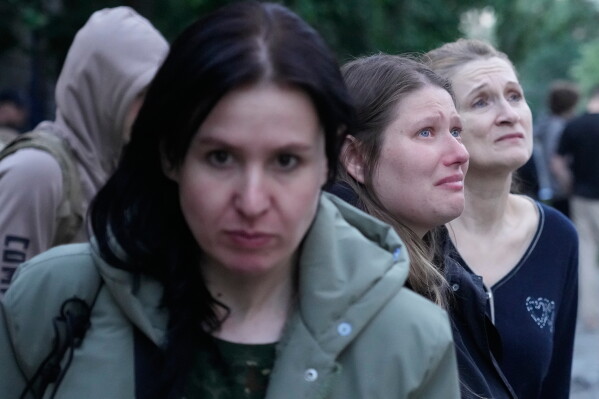 People react as they look at the site of Russian missile strike that hit a residential house in Kyiv, Ukraine, Sunday, May 24, 2026. (AP Photo/Efrem Lukatsky)