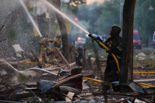 Rescue workers try to put out a fire at a residential building after a Russian strike on Kyiv, Ukraine, on Sunday, May 24, 2026. (AP Photo/Evgeniy Maloletka)