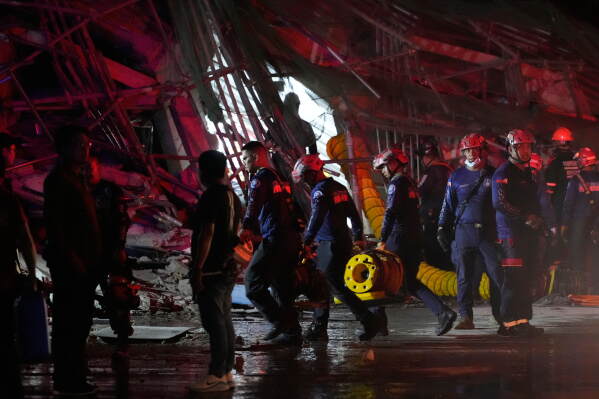 Rescue workers continue search at a collapsed building where multiple people are believed to be trapped in Angeles city in Pampanga province, north of Manila Sunday, May 24, 2026. (AP Photo/Aaron Favila)