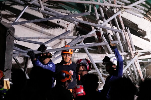Rescue workers continue searching a collapsed building where multiple people are believed to be trapped in Angeles city in Pampanga province, north of Manila Sunday, May 24, 2026. (AP Photo/Aaron Favila)