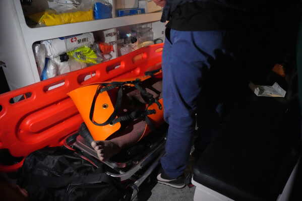Rescue workers bring a man to an ambulance after he was recovered from beneath the rubble of a collapsed building where multiple people are believed to be trapped in Angeles city in Pampanga province, north of Manila, Sunday, May 24, 2026. (AP Photo/Aaron Favila)