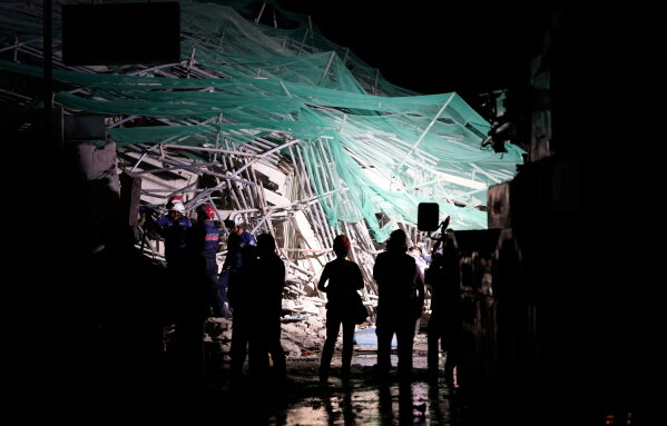 Rescue workers continue searching a collapsed building where multiple people are believed to be trapped in Angeles city in Pampanga province, north of Manila Sunday, May 24, 2026. (AP Photo/Aaron Favila)