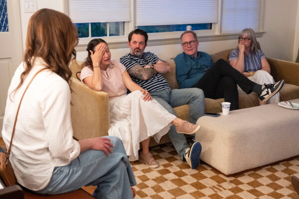 Kristina Jackson, right, talks about the overwhelming amount of screen time that happens at their children's school during a meeting with fellow school parents, Saturday, May 9, 2026 in Arlington, Va. (AP Photo/Kevin Wolf)