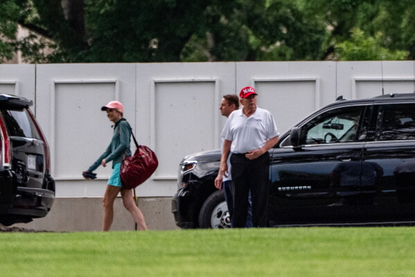 President Donald Trump, right, with White House aide Natalie Harp, left, walks to the White House after viewing the construction of the ballroom, Saturday, May 16, 2026, in Washington. (AP Photo/Alex Brandon)