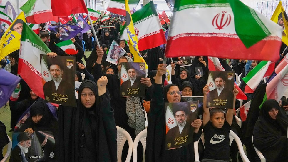 Government supporters hold Iranian flags and pictures of Iran's Supreme Leader, Ayatollah...