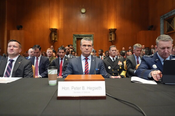 Acting Under Secretary of Defense and Comptroller Jules Hurst III, Defense Secretary Pete Hegseth and Chairman of the Joint Chiefs of Staff Gen. Dan Caine arrive to testify at a Senate Appropriations subcommittee on defense hearing on the budget request for the Department of Defense, Tuesday, May 12, 2026, in Washington. (AP Photo/Alex Brandon)