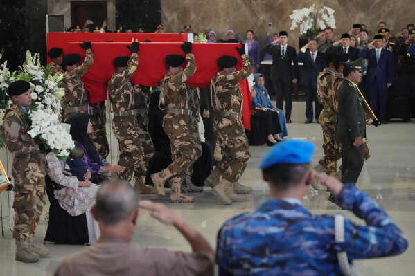 Soldiers carry the coffins of Indonesian peacekeepers who were killed while serving with the UN Interim Force in Lebanon, during an honor ceremony upon the arrival of their bodies at Soekarno-Hatta International Airport in Tangerang, Indonesia, April 4, 2026. (AP Photo/Achmad Ibrahim, File)