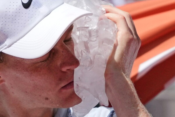 Jannik Sinner of Italy cools himself with the ice during the second round men's singles tennis match against Juan Manuel Cerundolo of Argentina at the French Open tennis tournament in Paris, Thursday, May 28, 2026. (AP Photo/Thibault Camus)