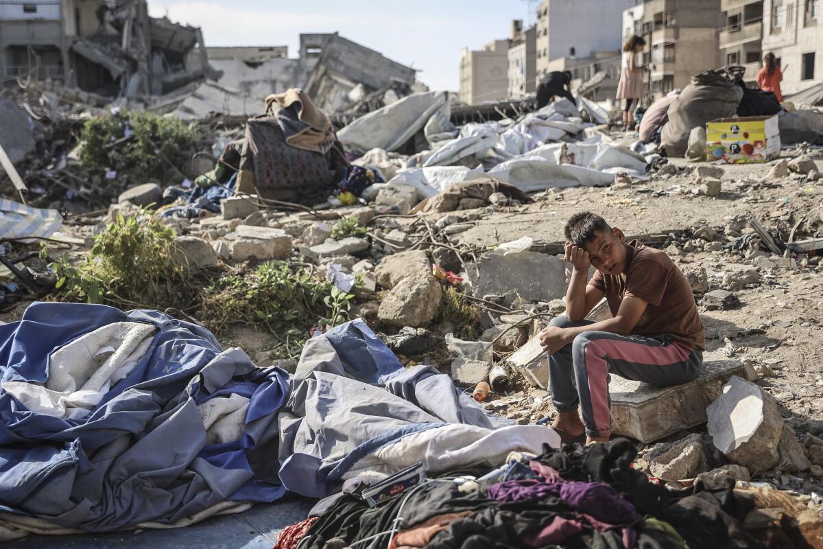 A Palestinian boy sits at the site of an overnight Israeli military strike on structures and tents housing displaced families