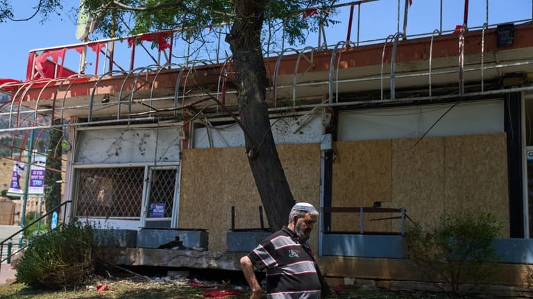 A local resident walks past the site struck by a...