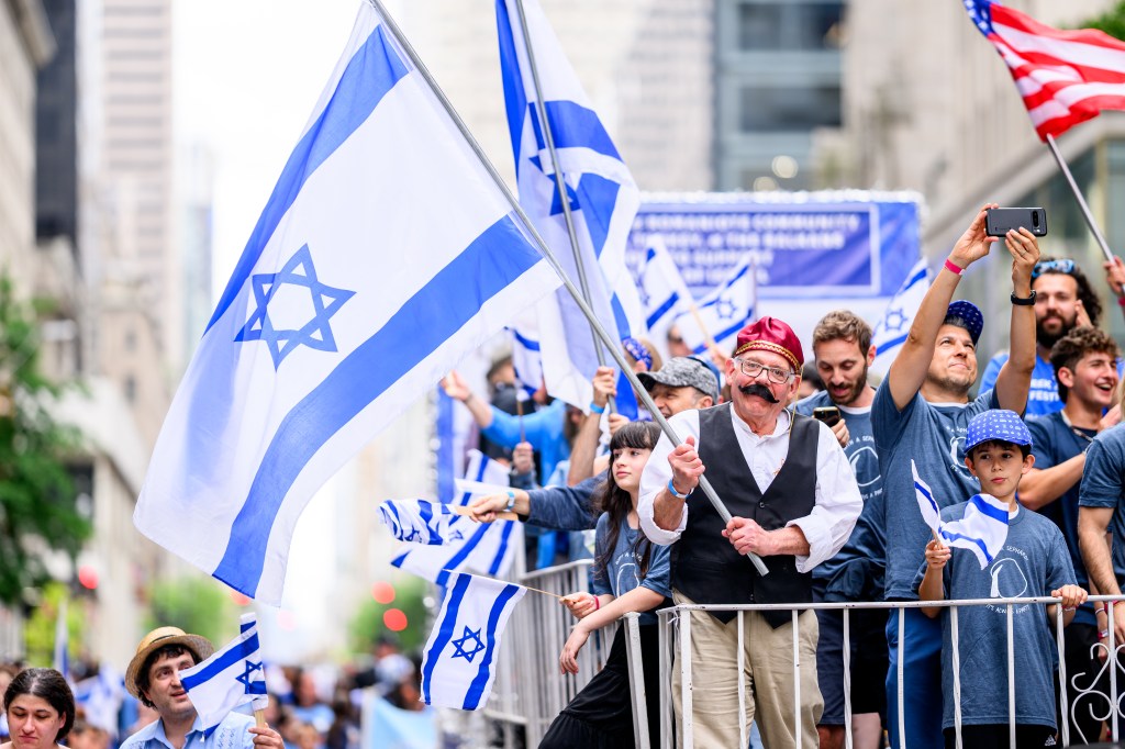 Celebrants waving Israeli flags during the Israel Day Parade.