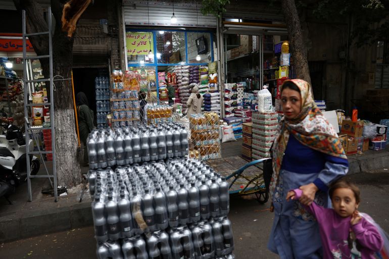 People walk in a local market in Tehran