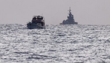 Israeli soldiers are seen on a vessel bearing symbols of the Global Sumud Flotilla, with an Israeli military ship behind it, as seen from Ashdod
