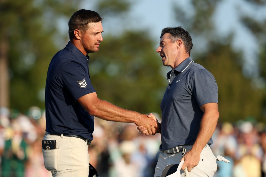 Rory McIlroy of Northern Ireland shakes hands with Bryson DeChambeau of the United States on the 18th hole during the final round of the 2025 Masters Tournament at Augusta National Golf Club on April 13, 2025 in Augusta, Georgia.