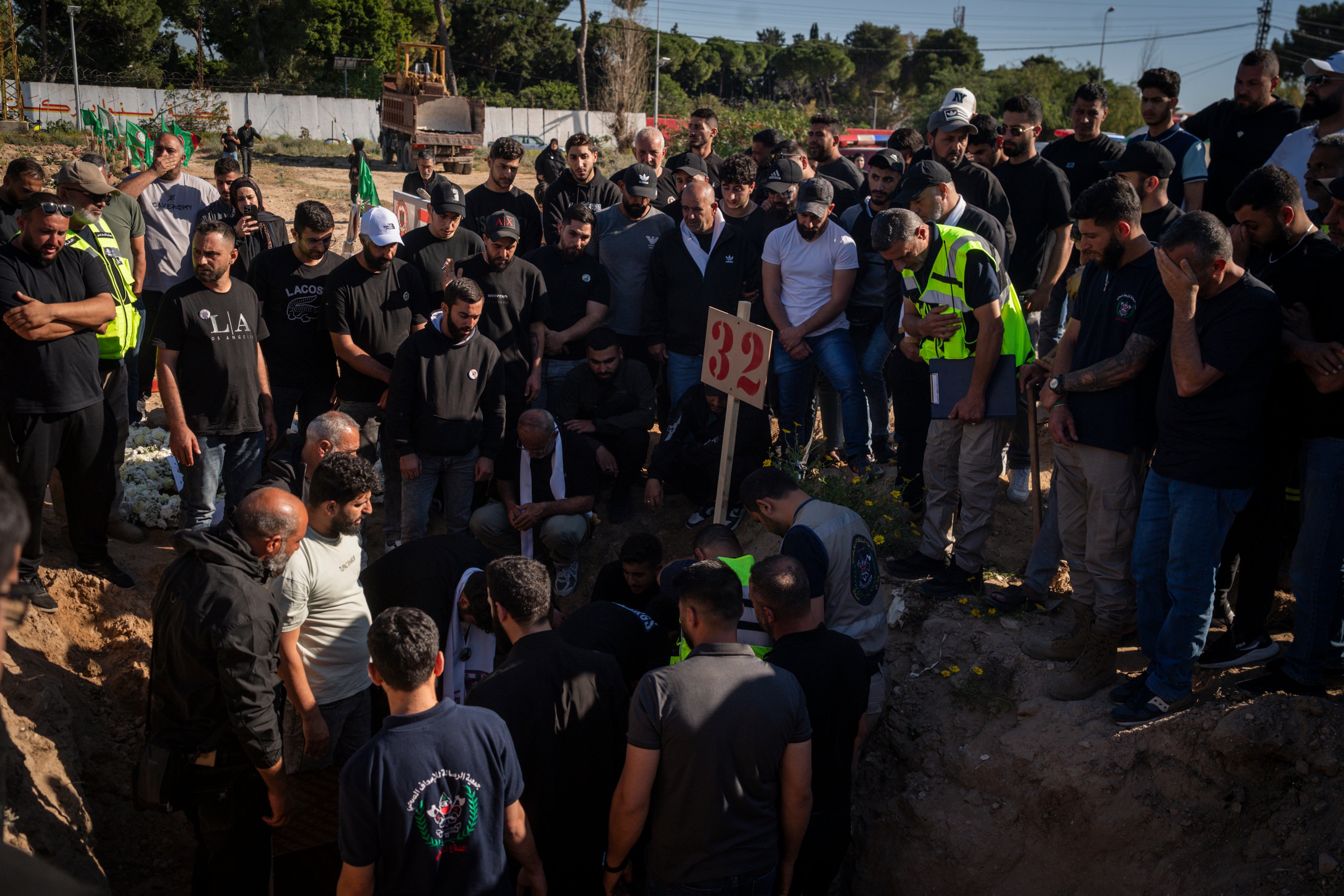 Mourners gather during a funeral at a makeshift cemetery for Hussein Ghadbouni, one of three members of the Lebanese Civil Defense were killed in an Israeli airstrike on Tuesday