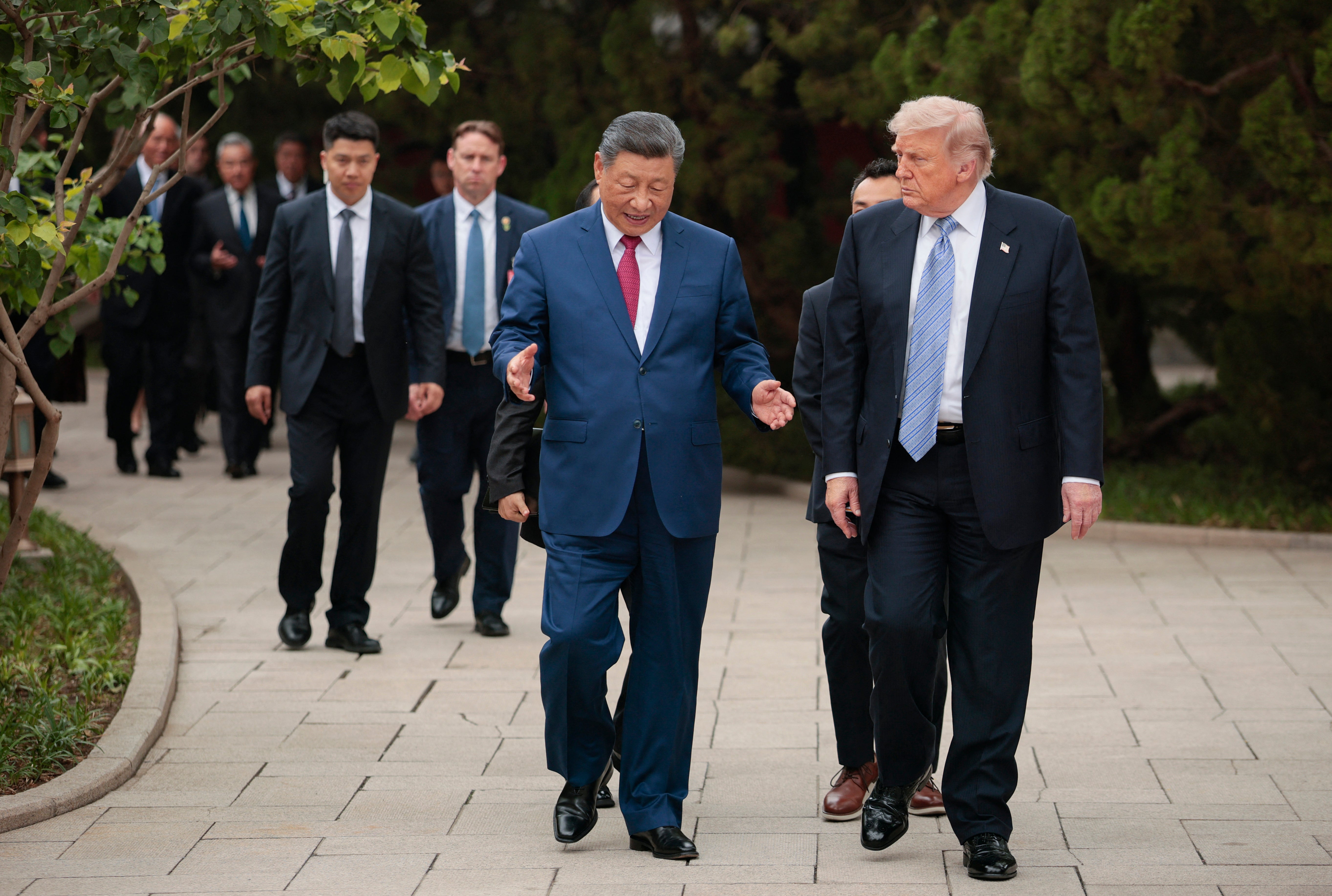 US President Donald Trump (R) walks with China's President Xi Jinping (C) as he leaves after a visit to Zhongnanhai Garden in Beijing
