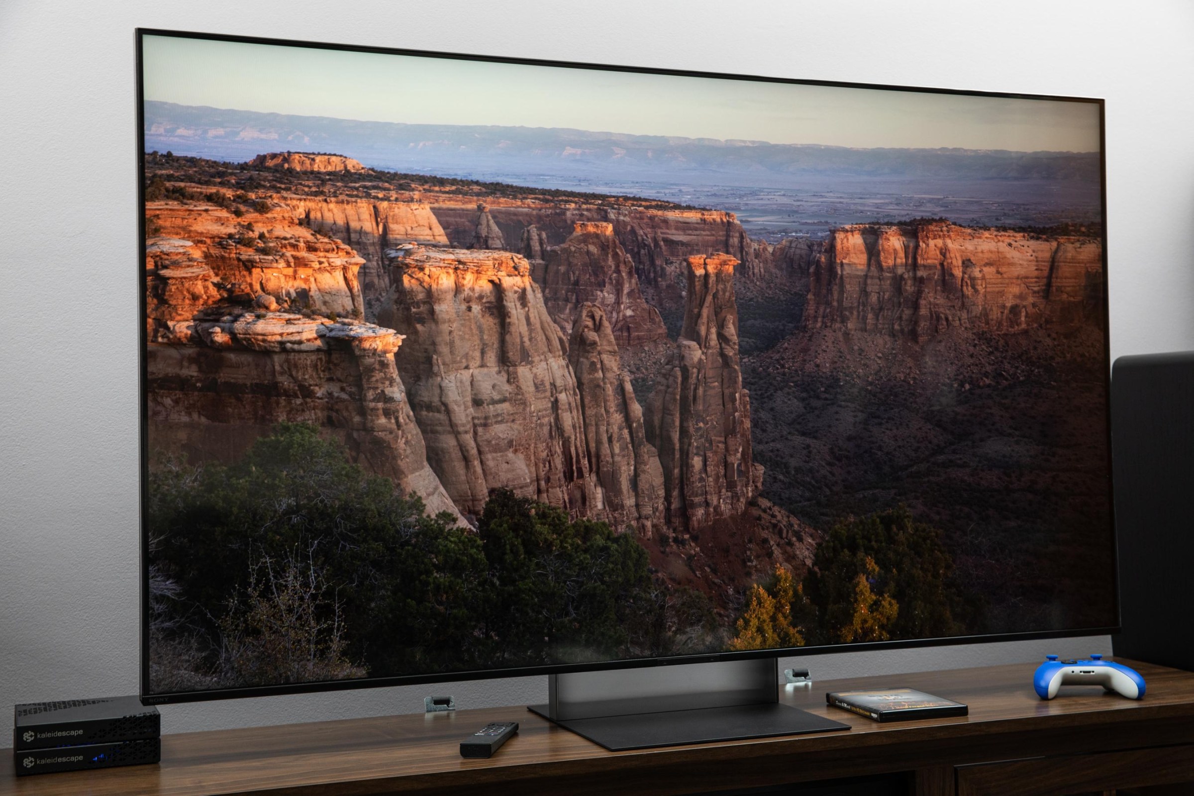 The Sony Bravia 7 II RGB LED TV on a dark wooden credenza displaying an image of rock formations.