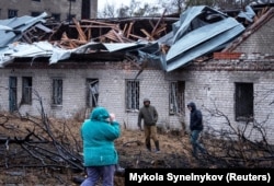 Residents of the eastern city of Dnipro look at damage caused to a building following the first use of an Oreshnik missile against Ukraine in November 2024.