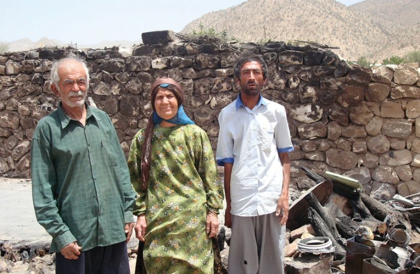 A BAHA’I family in Fars province stands near where an arson attack was committed.